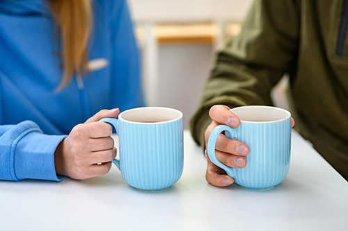 Hands holding mugs of tea
